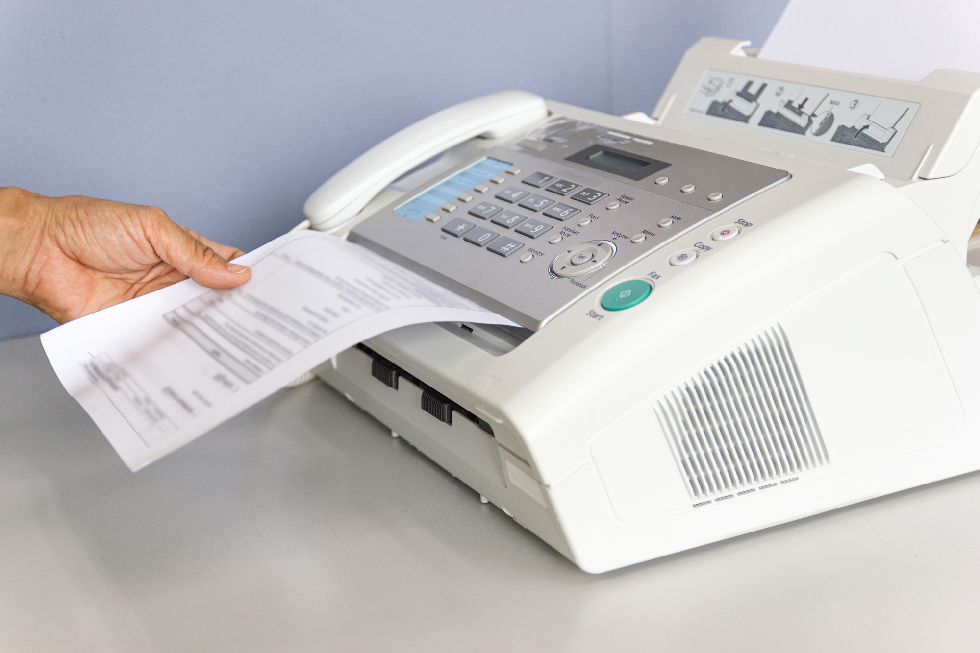 hand man are using a fax machine in the office